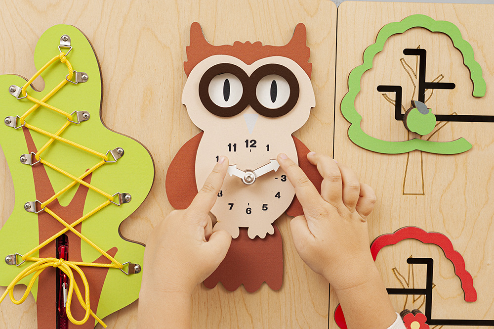 Close-up of tactile gears and latches on a pediatric sensory wall panel